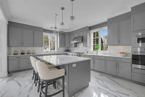 a kitchen with a stove a sink dishwasher a dining table and chairs