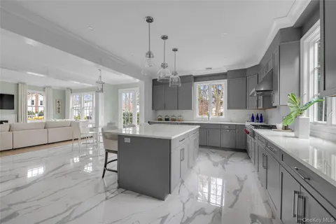 a large kitchen with kitchen island a sink stainless steel appliances and cabinets