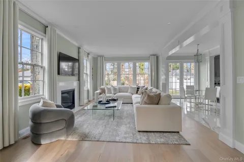 a living room with fireplace furniture and floor to ceiling windows