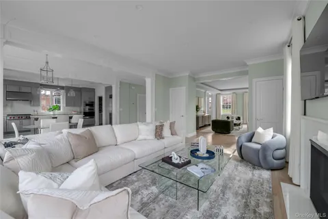 a living room with furniture couches and a dining table with wooden floor