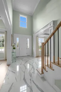 a view of a hallway with wooden floor and windows