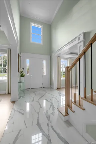 a view of a hallway with wooden floor and windows