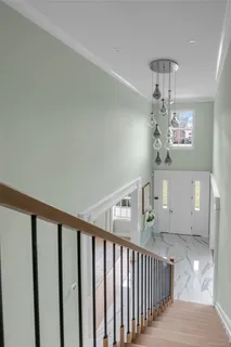 a view of a hallway with windows and chandelier