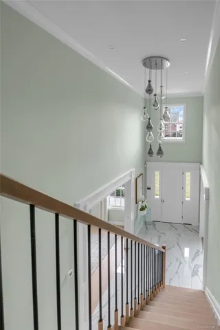 a view of a hallway with windows and chandelier