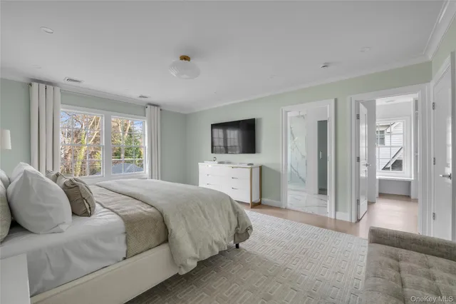 a spacious bedroom with a bed and a flat screen tv