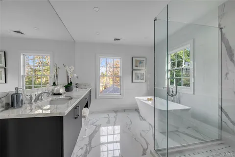a large bathroom with a granite countertop tub a sink and a large mirror