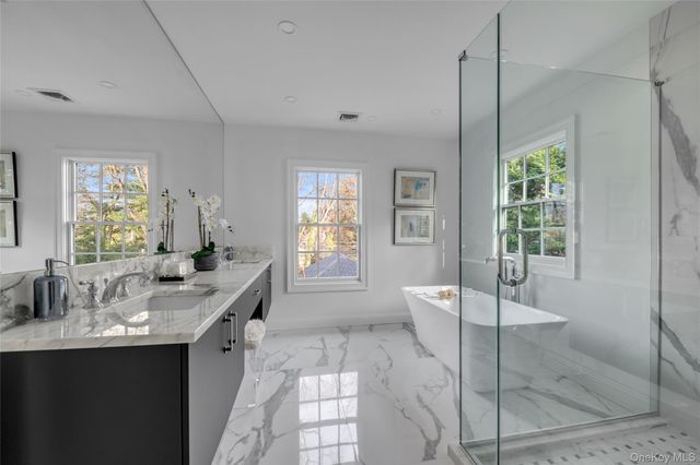 a large bathroom with a granite countertop tub a sink and a large mirror