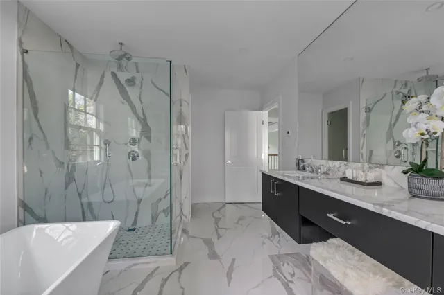 a spacious bathroom with a double vanity sink toilet mirror and bathtub