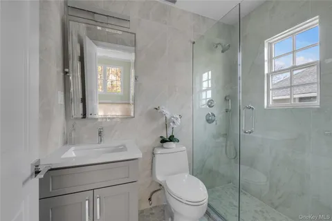 a bathroom with a toilet sink vanity and mirror