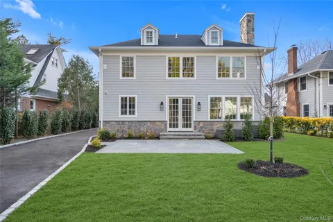 a front view of a house with a yard and green space