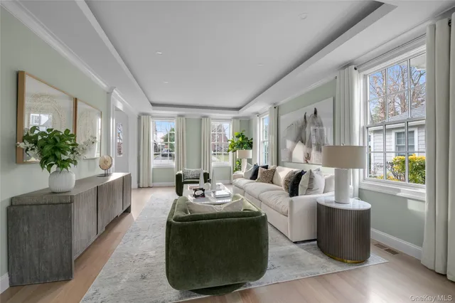 a living room with furniture large window and wooden floor