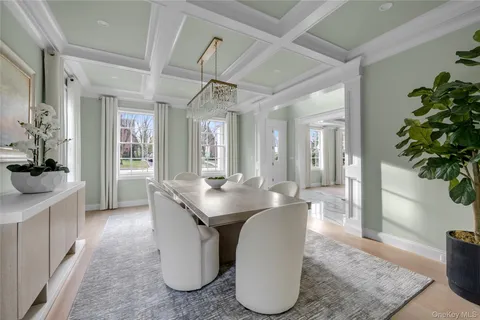 a dining room with chandelier fan and wooden floor