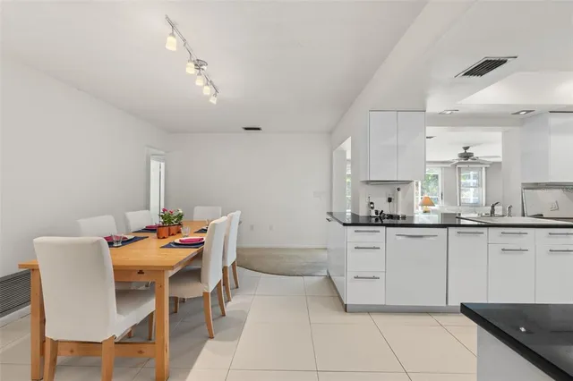 a kitchen with granite countertop white cabinets and chairs