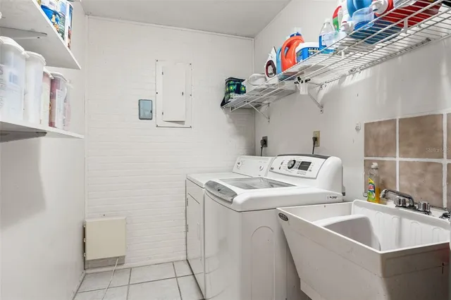 a view of a patio with couches table and chairs under an umbrella
