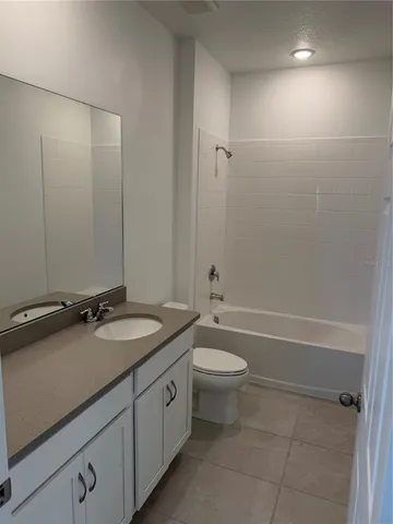 a bathroom with a granite countertop sink a toilet and bathtub
