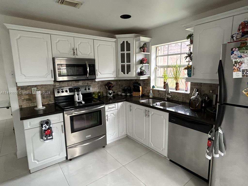Marbella Park Hialeah, FL 33015 - Photo 18 of 24 a kitchen with granite countertop a sink and steel appliances