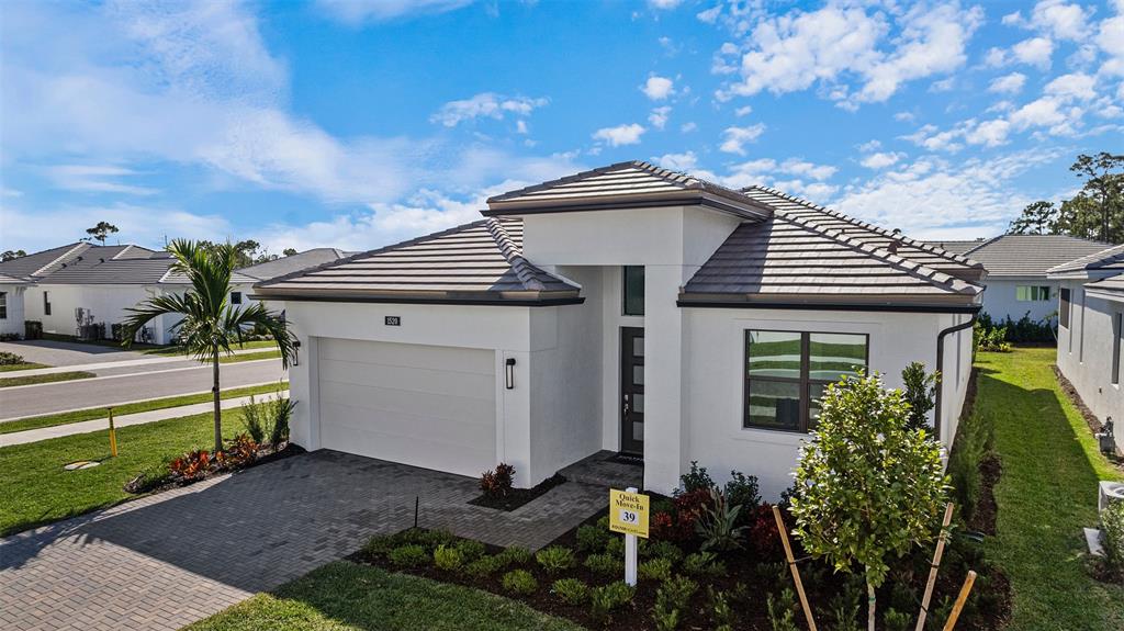 1520 Southeast Savoy Way Stuart, FL 34997 - Photo 3 of 39 a front view of a house with garden