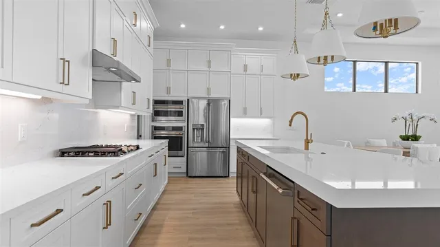 a kitchen with stainless steel appliances granite countertop a sink stove and refrigerator