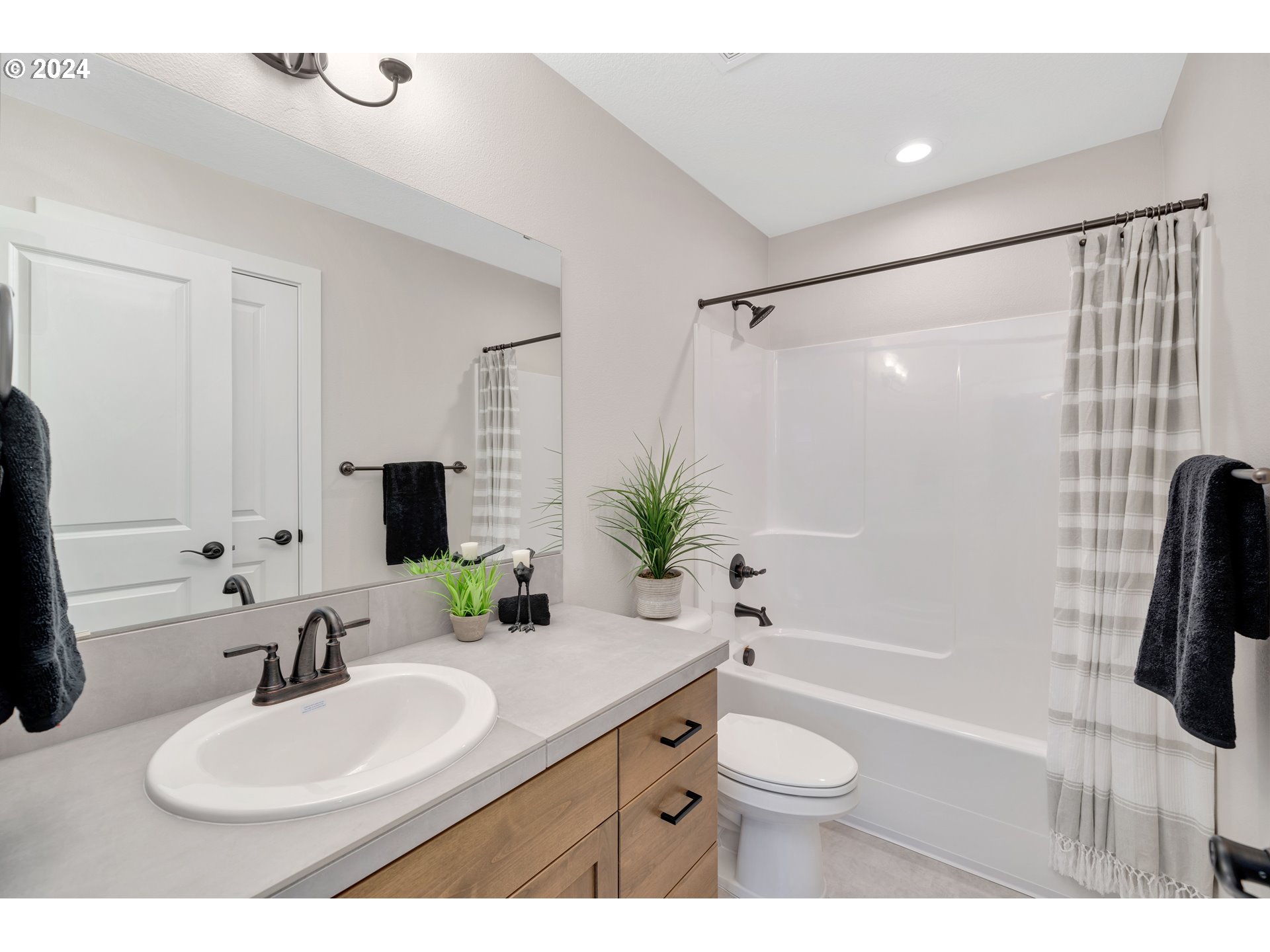 17538 Northwest 7th Avenue Ridgefield, WA 98642 - Photo 10 of 18 a bathroom with a granite countertop sink toilet a large mirror a shower and a tub