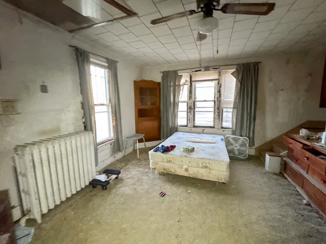 a spacious bedroom with a bed and a chandelier