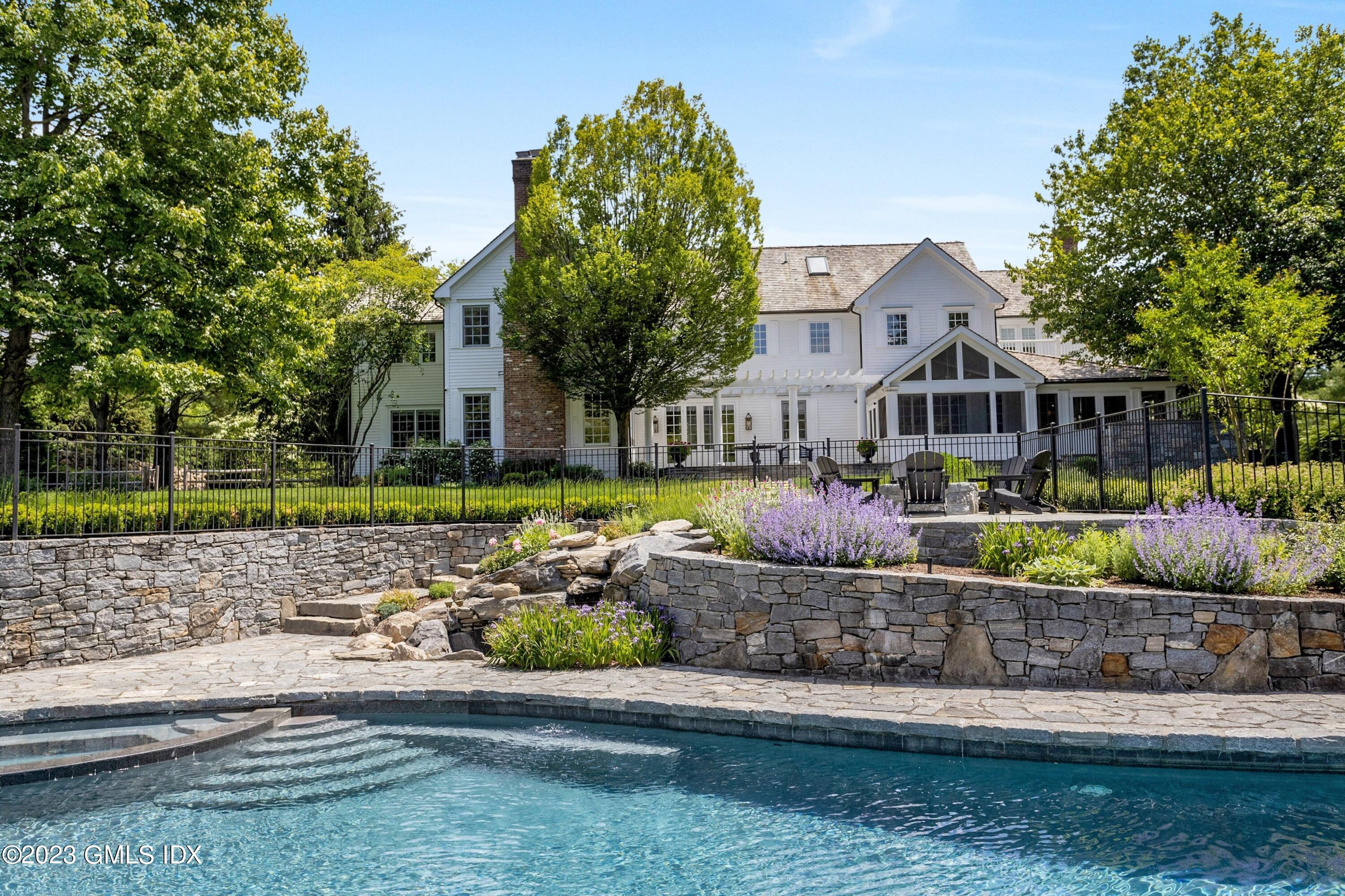 400 Stanwich Road Greenwich, CT 06830 - Photo 26 of 37 a front view of a house with a yard and a garden