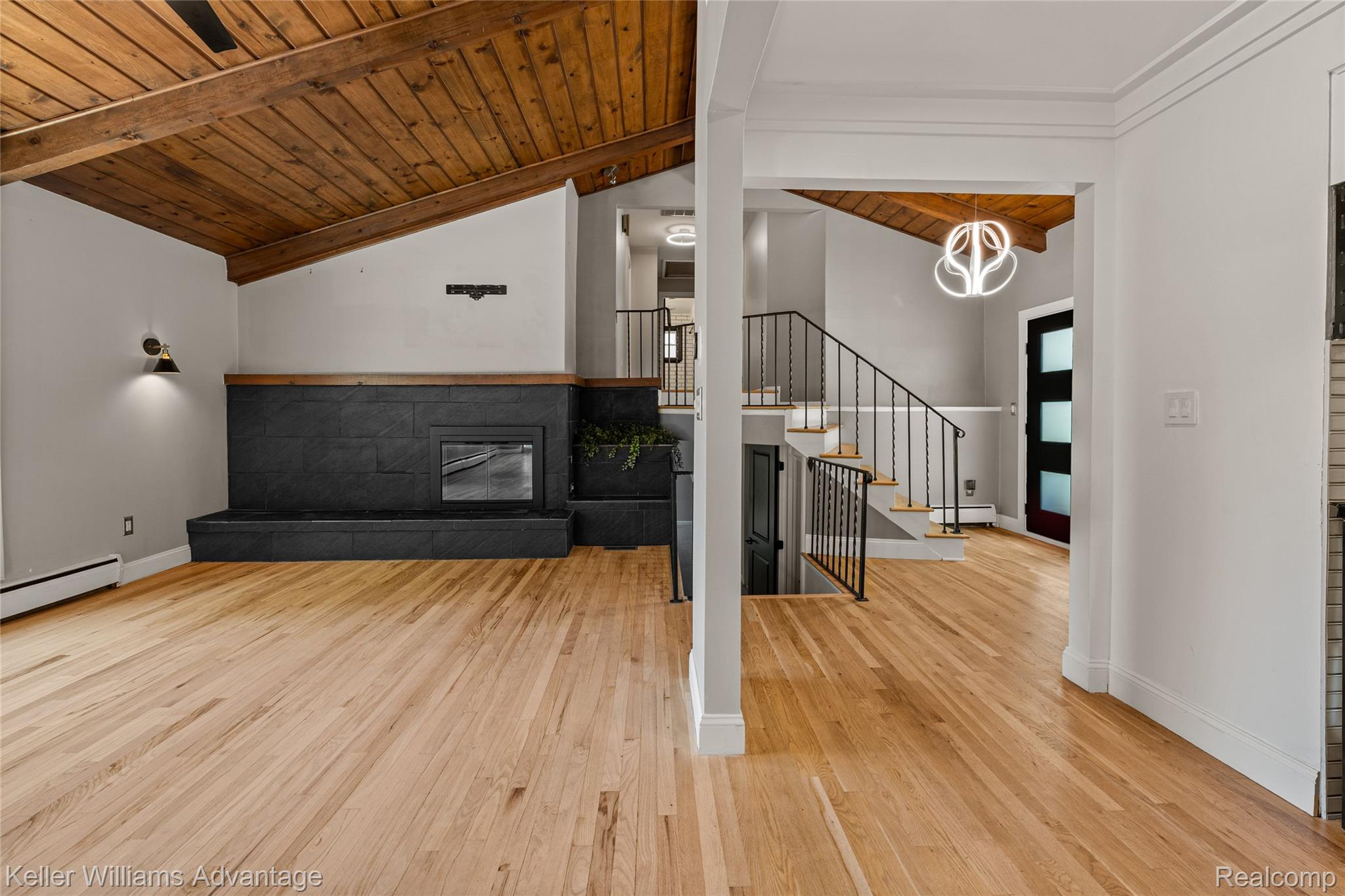 5722 Raven Road Bloomfield Hills, MI 48301 - Photo 8 of 34 Open-concept living area featuring wood-finish flooring, a vaulted wood plank ceiling, and a prominent black slate-style fireplace