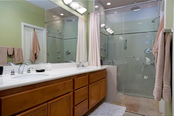 a bathroom with a double vanity sink mirror and shower