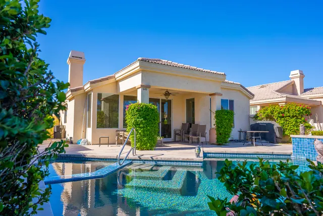 a front view of house with swimming pool and green space