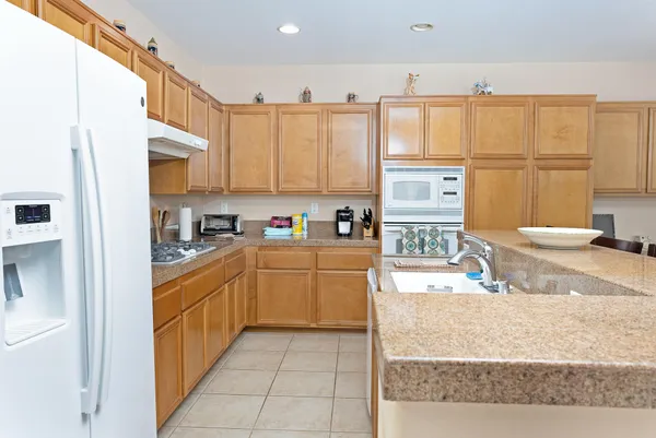 a kitchen with stainless steel appliances granite countertop a refrigerator sink and cabinets