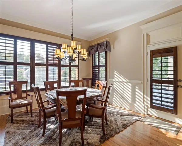 a view of a dining room with furniture large windows and wooden floor
