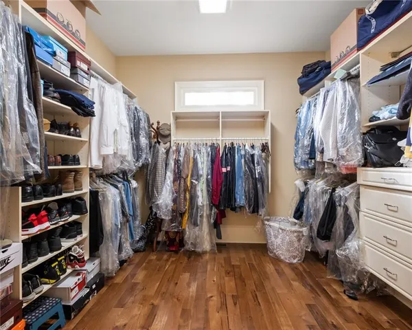 a view of walk in closet with clothes and shoes