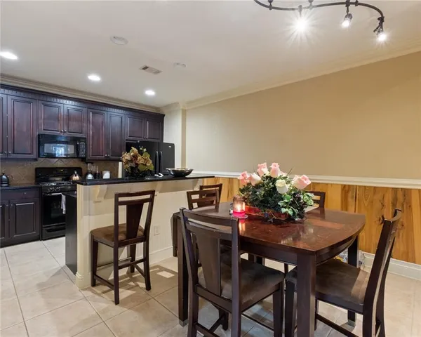 a kitchen with granite countertop a table chairs microwave and cabinets