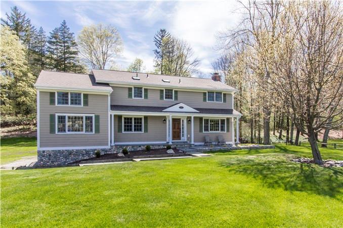 183 Holmes Road Ridgefield, CT 06877 - Photo 1 of 1 a front view of a house with a garden and trees