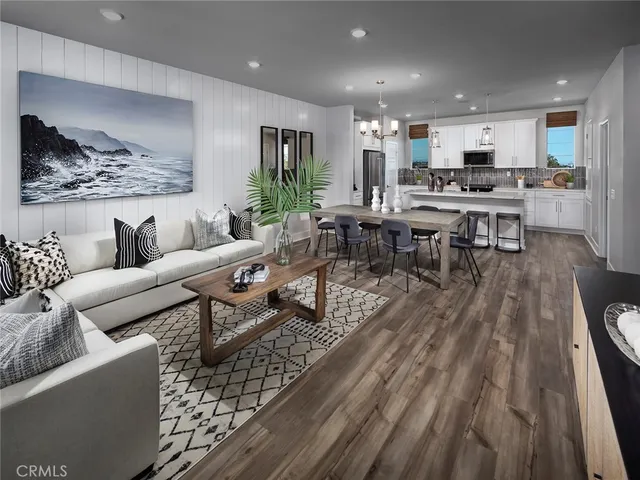 a living room with lots of furniture and view of kitchen