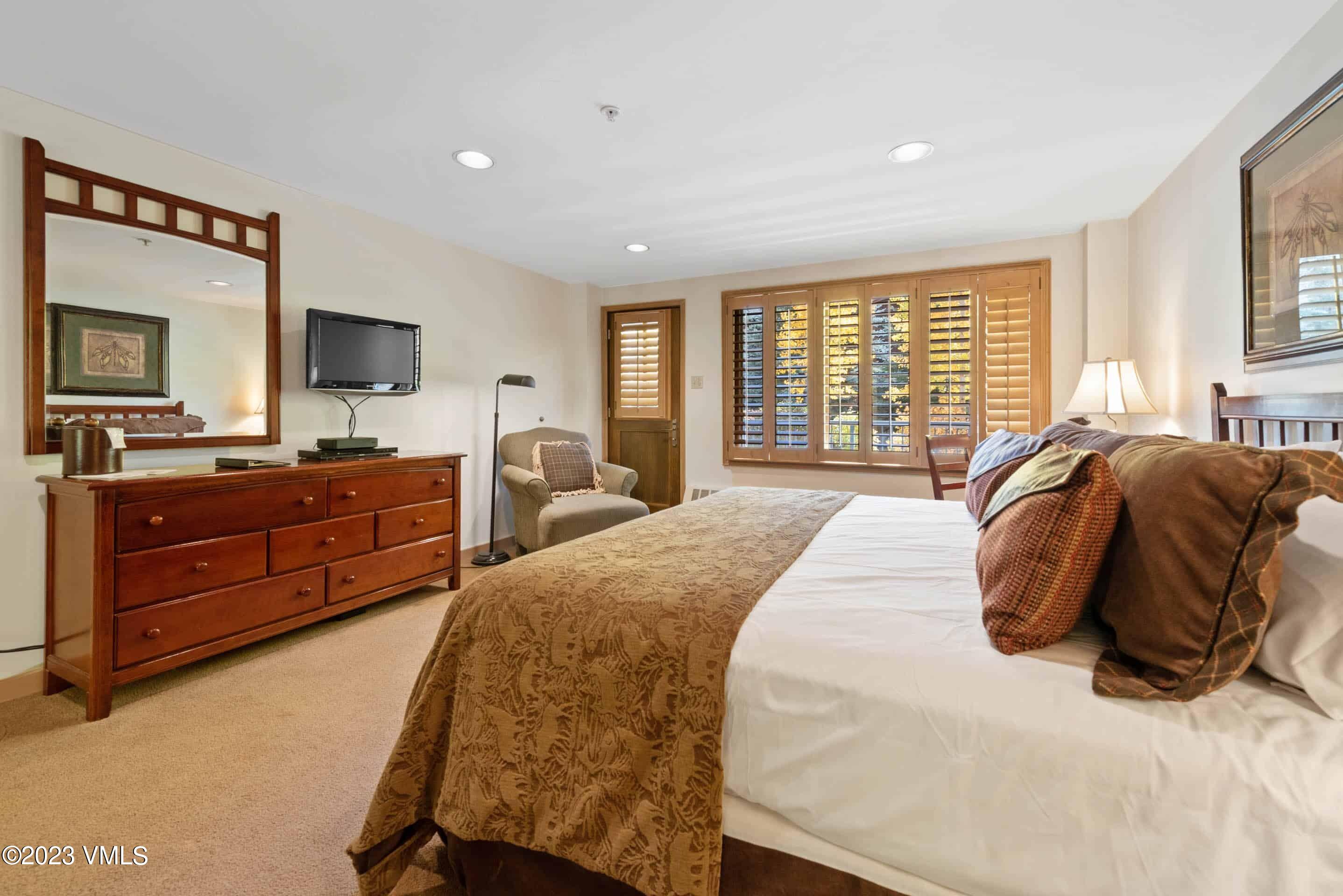 200 Vail Road, Unit 287 Vail, CO 81657 - Photo 11 of 21 a bedroom with a large bed and a flat tv screen on dresser