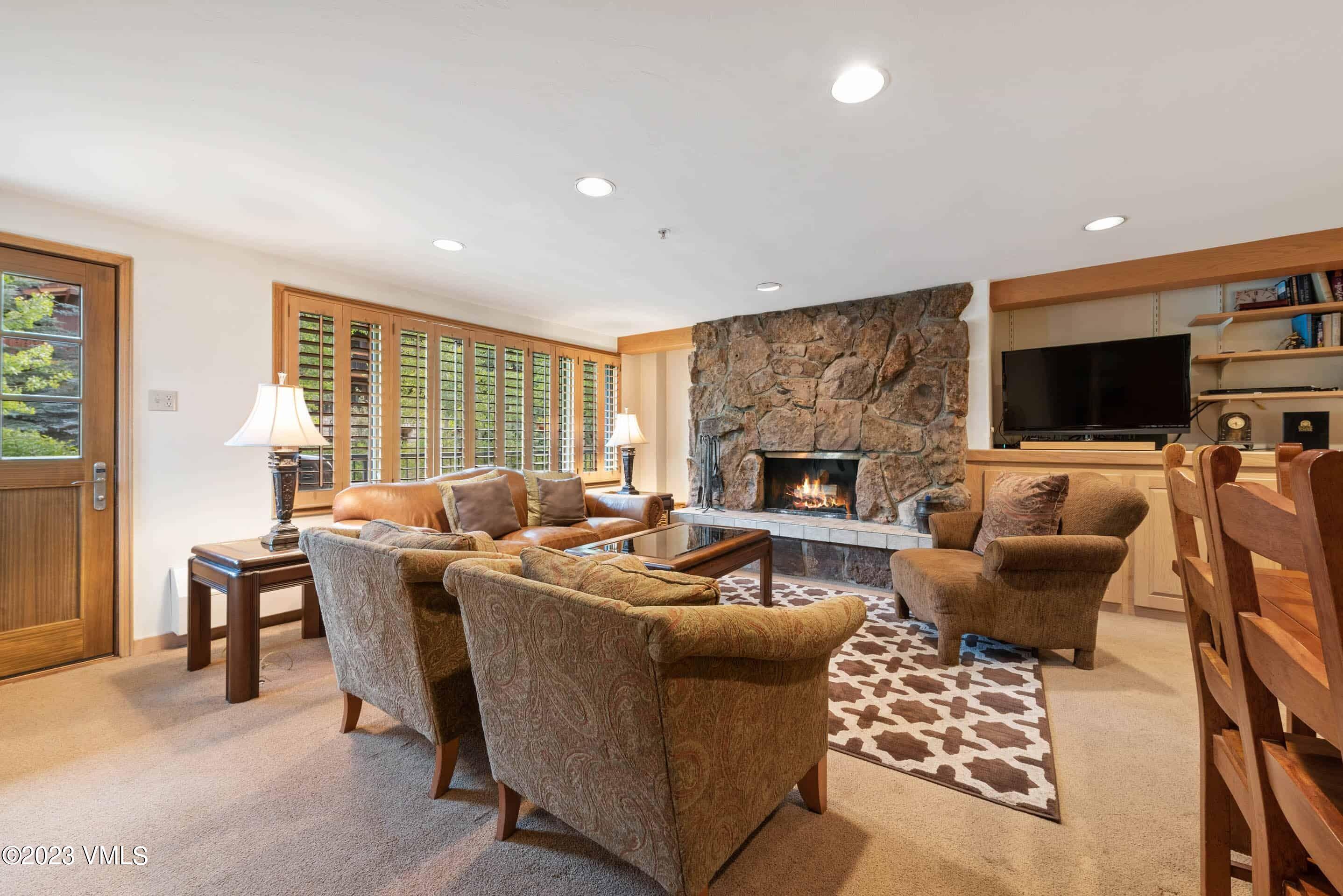 200 Vail Road, Unit 287 Vail, CO 81657 - Photo 5 of 21 a living room with furniture a flat screen tv and a fireplace