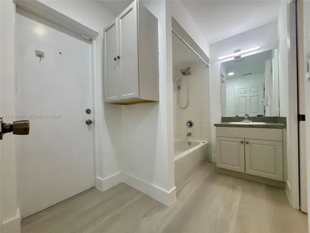 a bathroom with a bathtub sink and mirror
