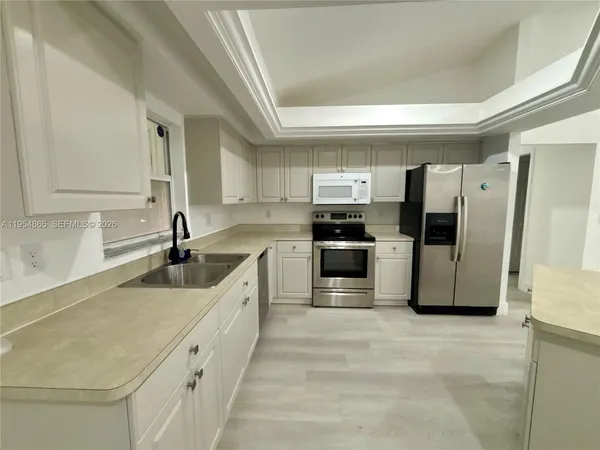 a large kitchen with a refrigerator and a sink