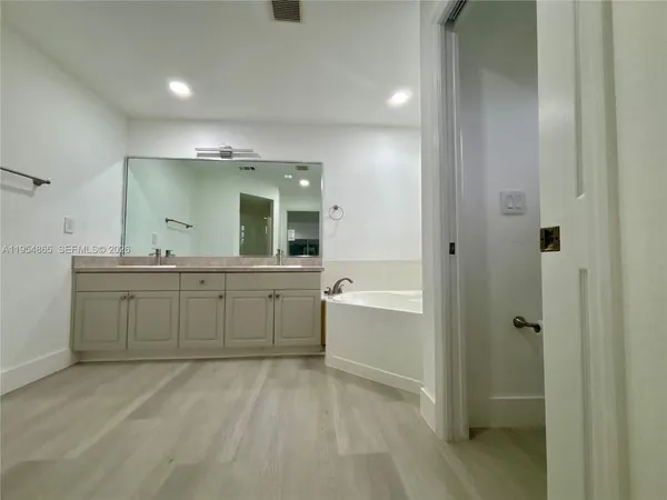 a bathroom with a granite countertop sink mirror and bathtub