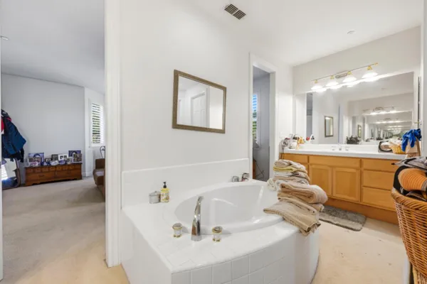 a bathroom with a tub a sink and a mirror