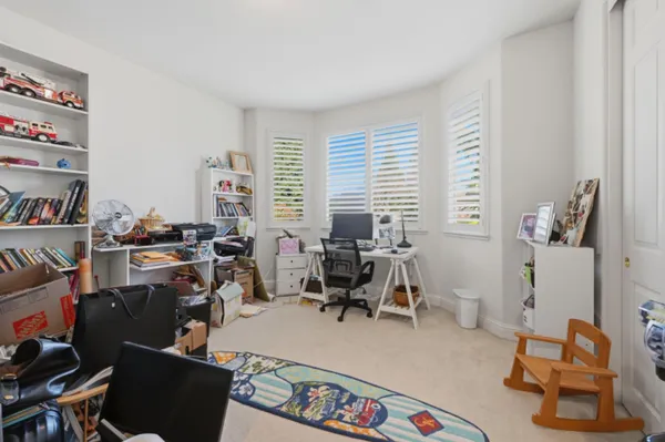 a view of a workspace with furniture and a window