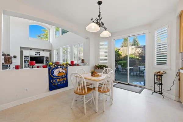 a dining room with furniture a chandelier and a flat screen tv