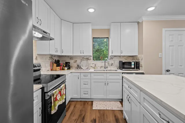 a kitchen with a sink cabinets appliances and a window