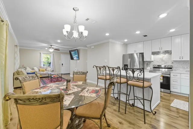 an open kitchen with dining table and stainless steel appliances