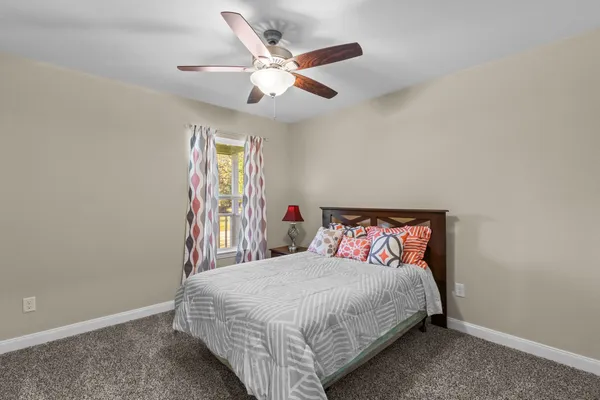 a bedroom with a large bed and a chandelier