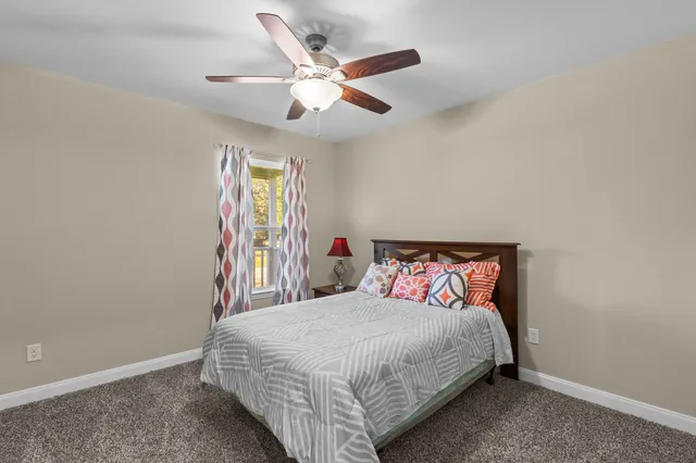 a bedroom with a large bed and a chandelier