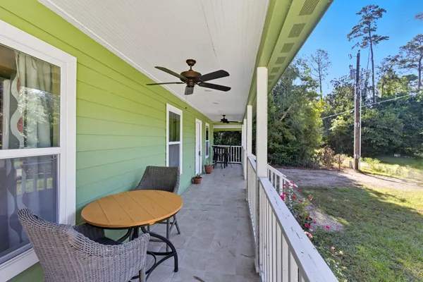 a view of a porch with furniture and a yard