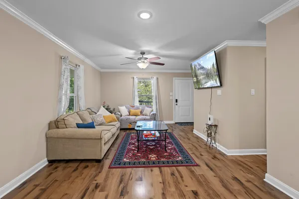 a living room with furniture and a wooden floor