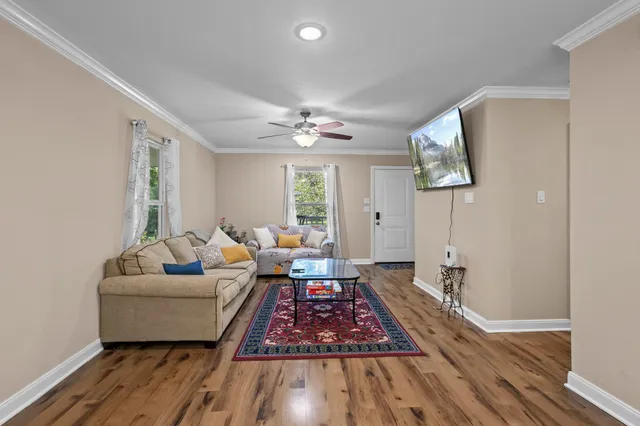 a living room with furniture and a wooden floor
