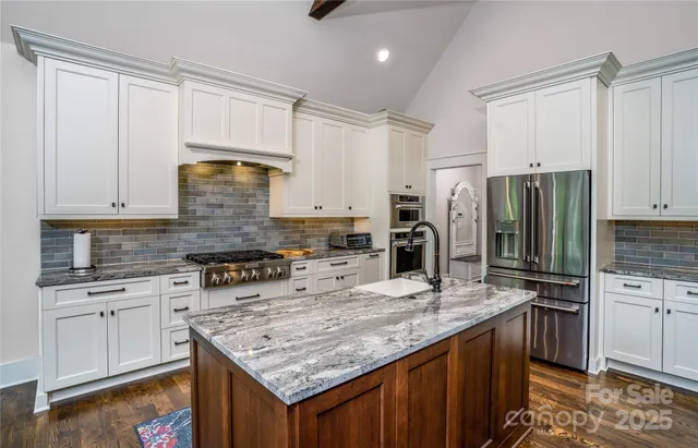 a kitchen with kitchen island granite countertop a sink stove and refrigerator